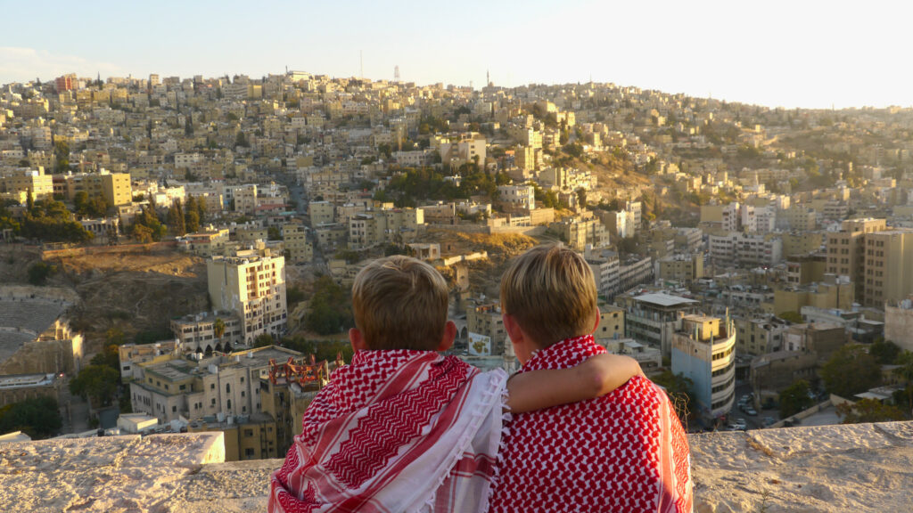 Jongens op de Citadel met skyline van Amman op de achtergrond.